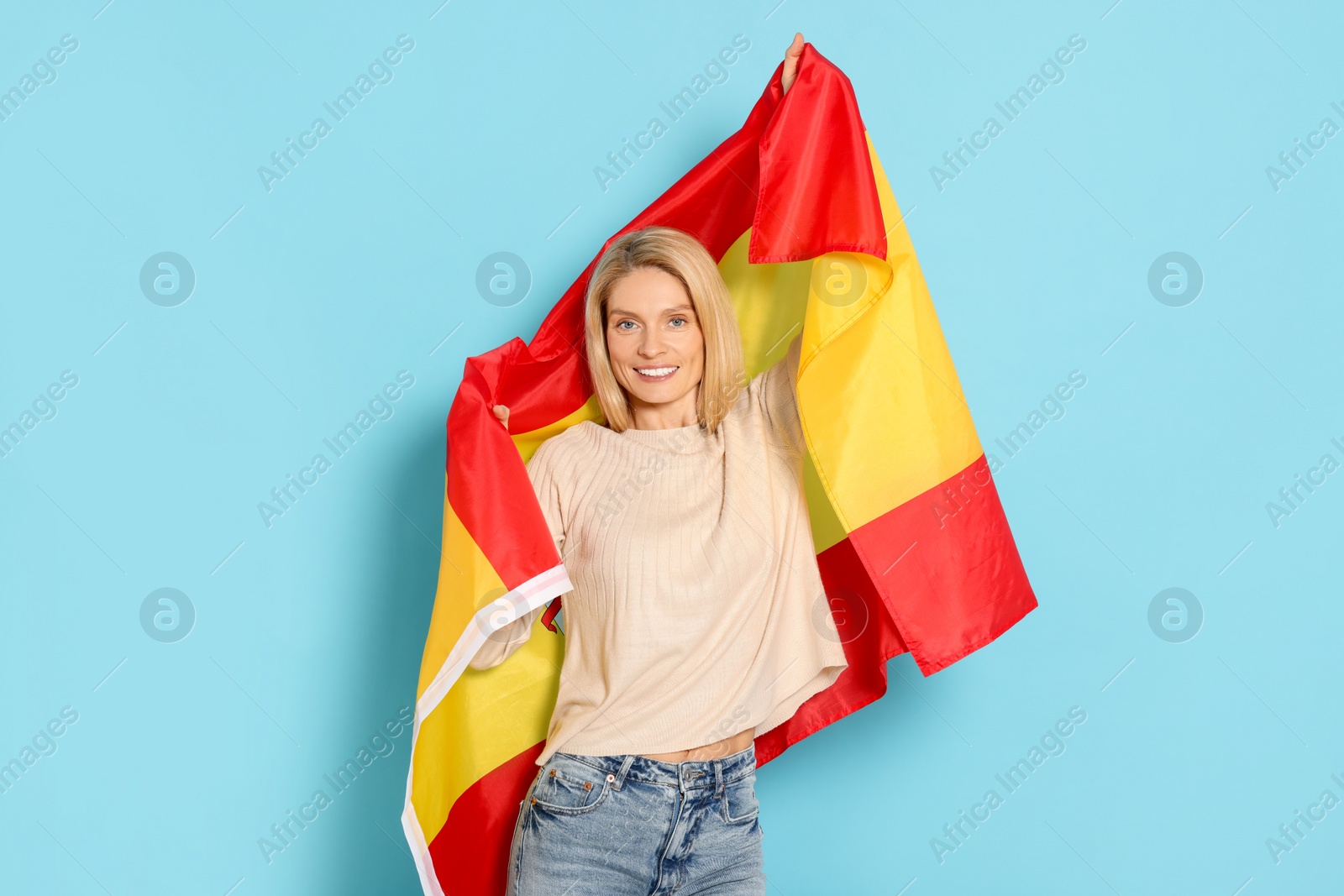 Photo of Woman with flag of Spain on light blue background