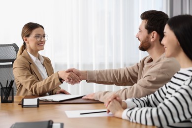 Photo of Lawyer shaking hands with clients in office