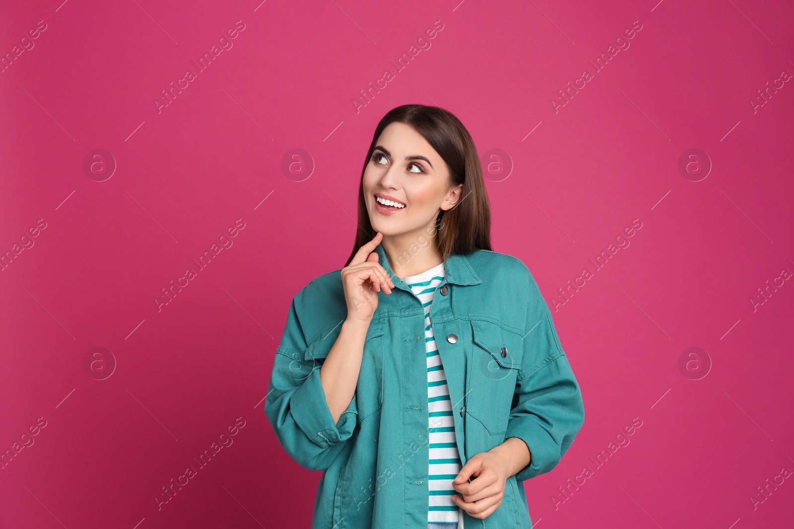 Photo of Portrait of happy young woman on pink background