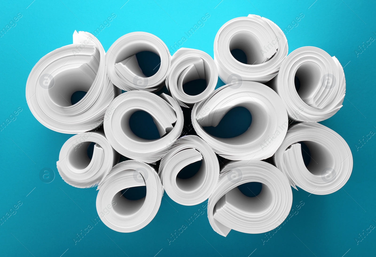 Photo of Blank white paper rolls on light blue background, flat lay