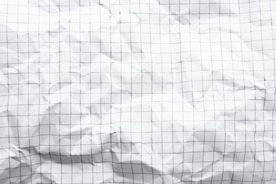 Crumpled checkered notebook sheet as background, top view