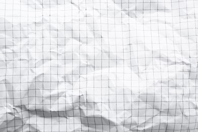 Photo of Crumpled checkered notebook sheet as background, top view