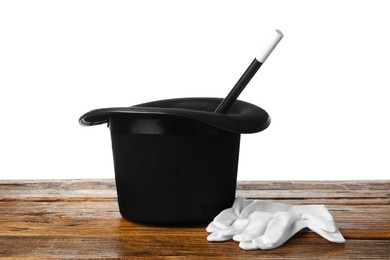 Photo of Magician's hat, gloves and wand on wooden table against white background