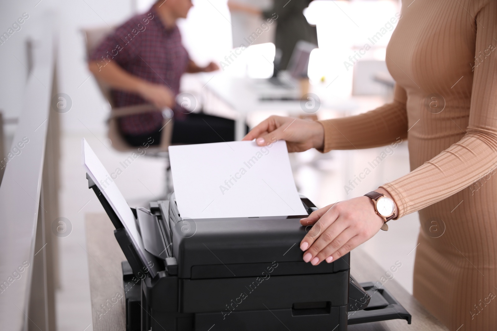 Photo of Employee using modern printer in office, closeup