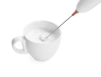 Whisking milk in cup with mini mixer (frother wand) isolated on white, closeup