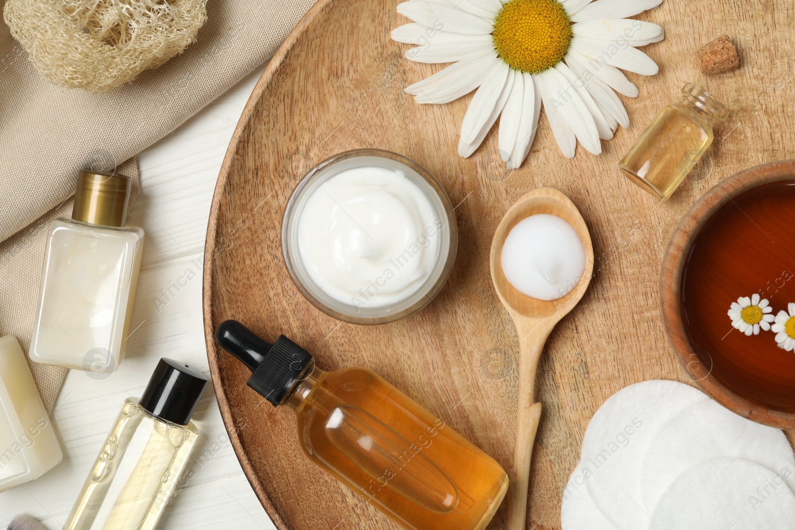 Photo of Flat lay composition with chamomile and cosmetic products on white wooden table