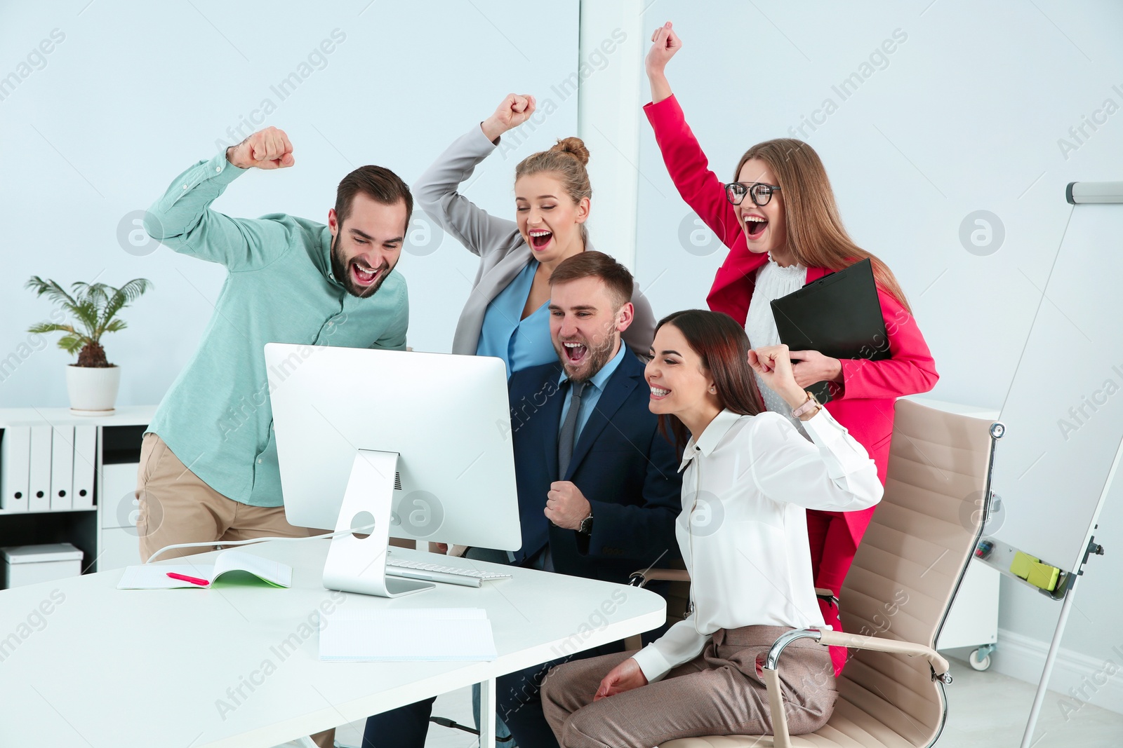 Photo of Group of office employees celebrating victory at workplace