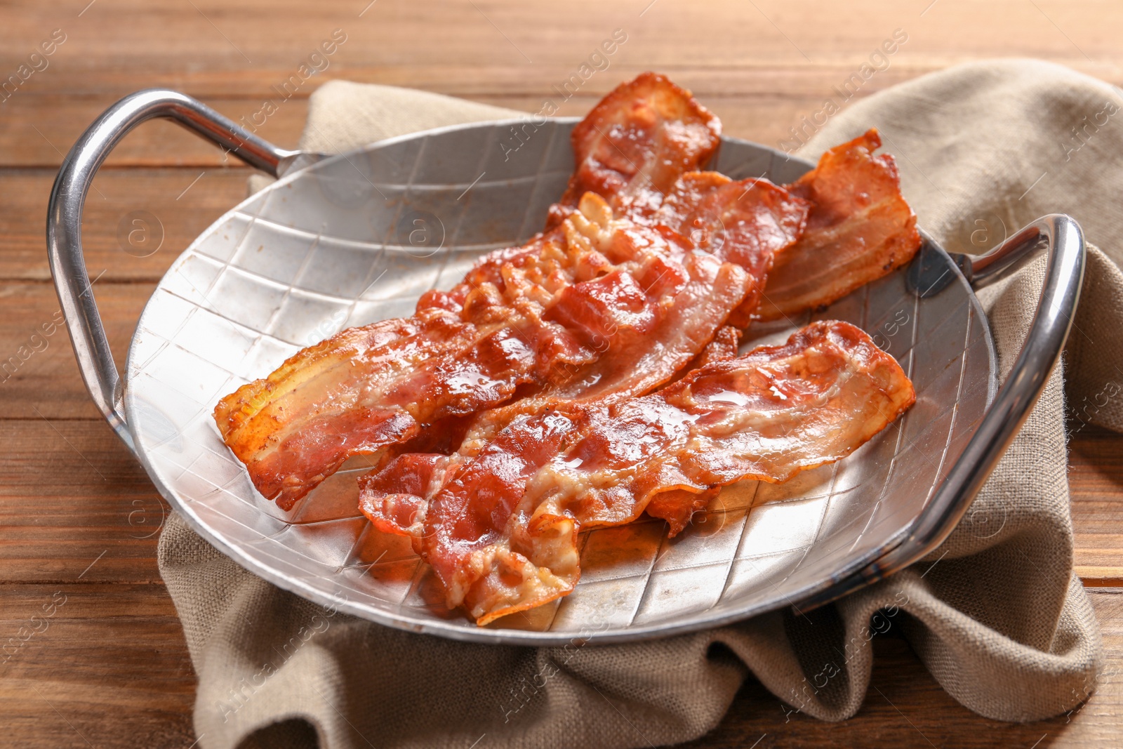 Photo of Dish with fried bacon on wooden background