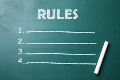 Image of White chalk stick on greenboard and list of rules, top view