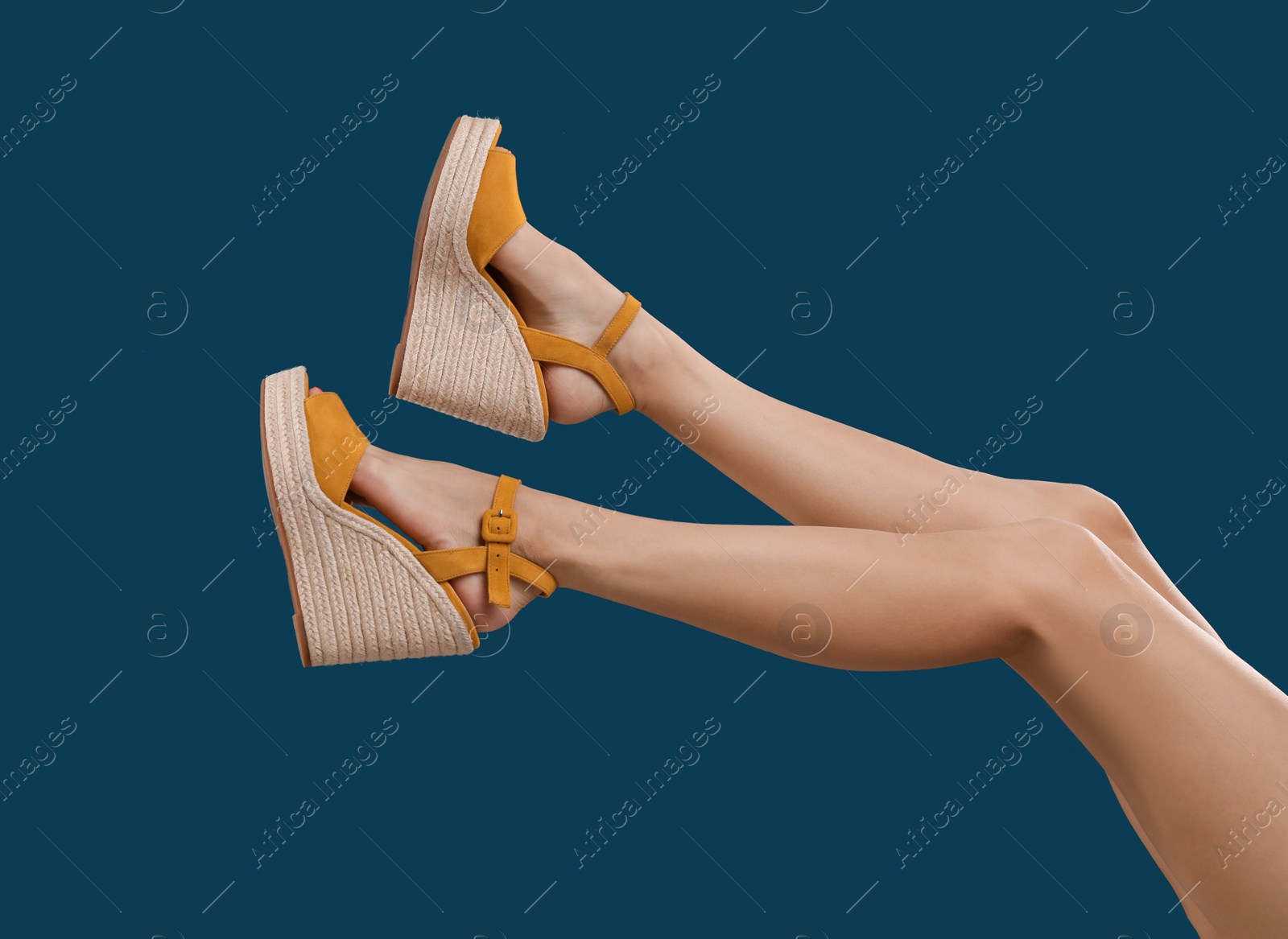 Photo of Woman in stylish shoes on dark blue background