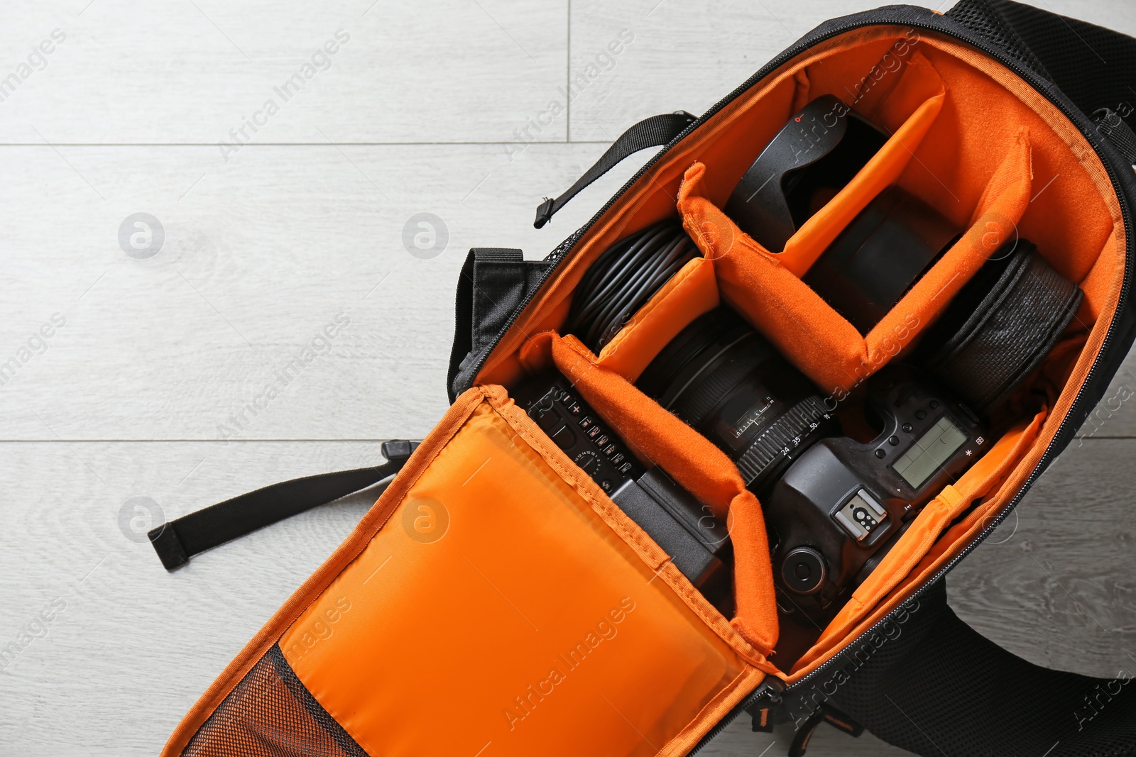 Photo of Bag with digital camera on floor. Professional photographer's equipment