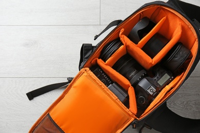 Photo of Bag with digital camera on floor. Professional photographer's equipment