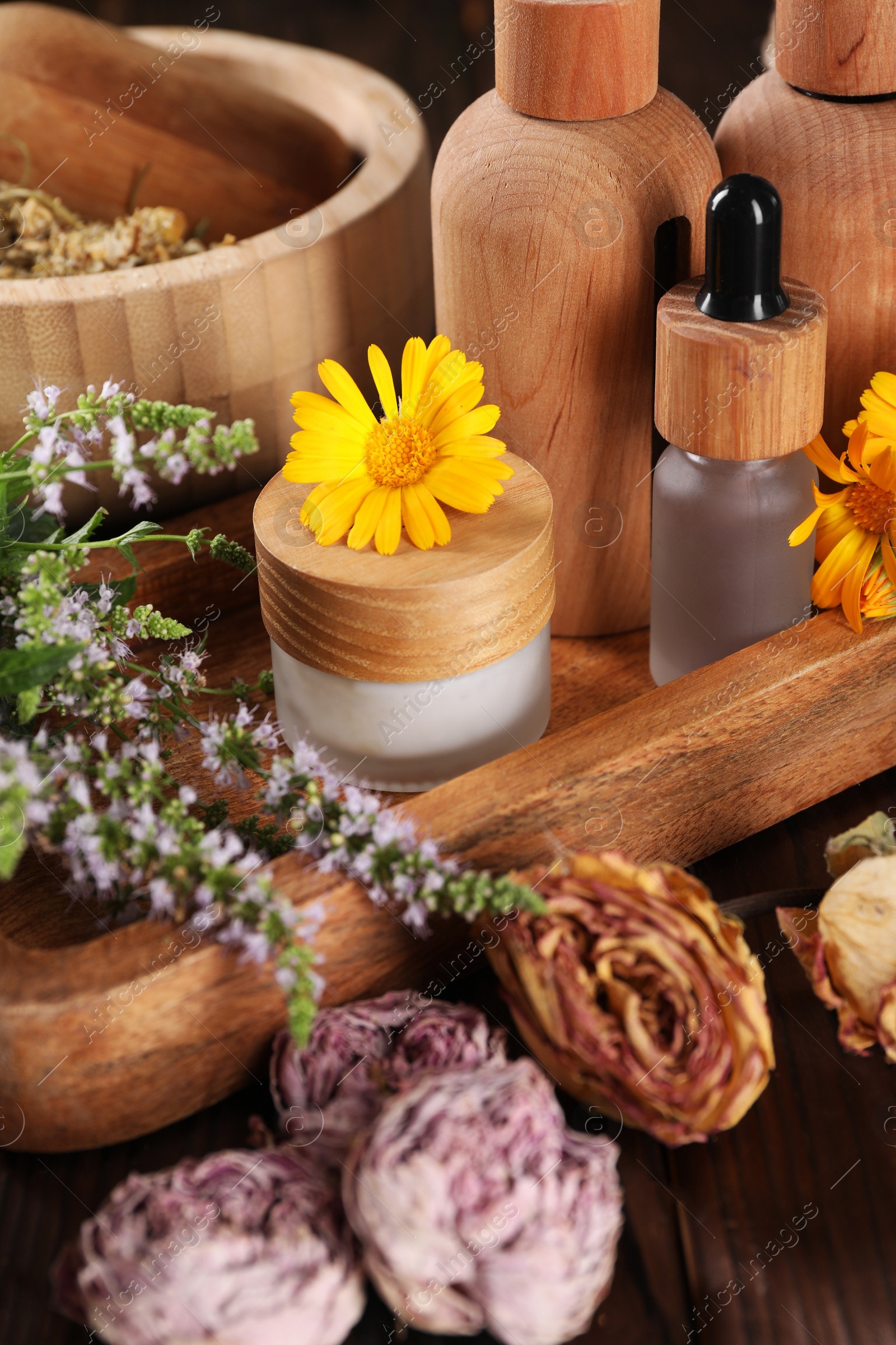 Photo of Jar, bottles of essential oils and different herbs on wooden table