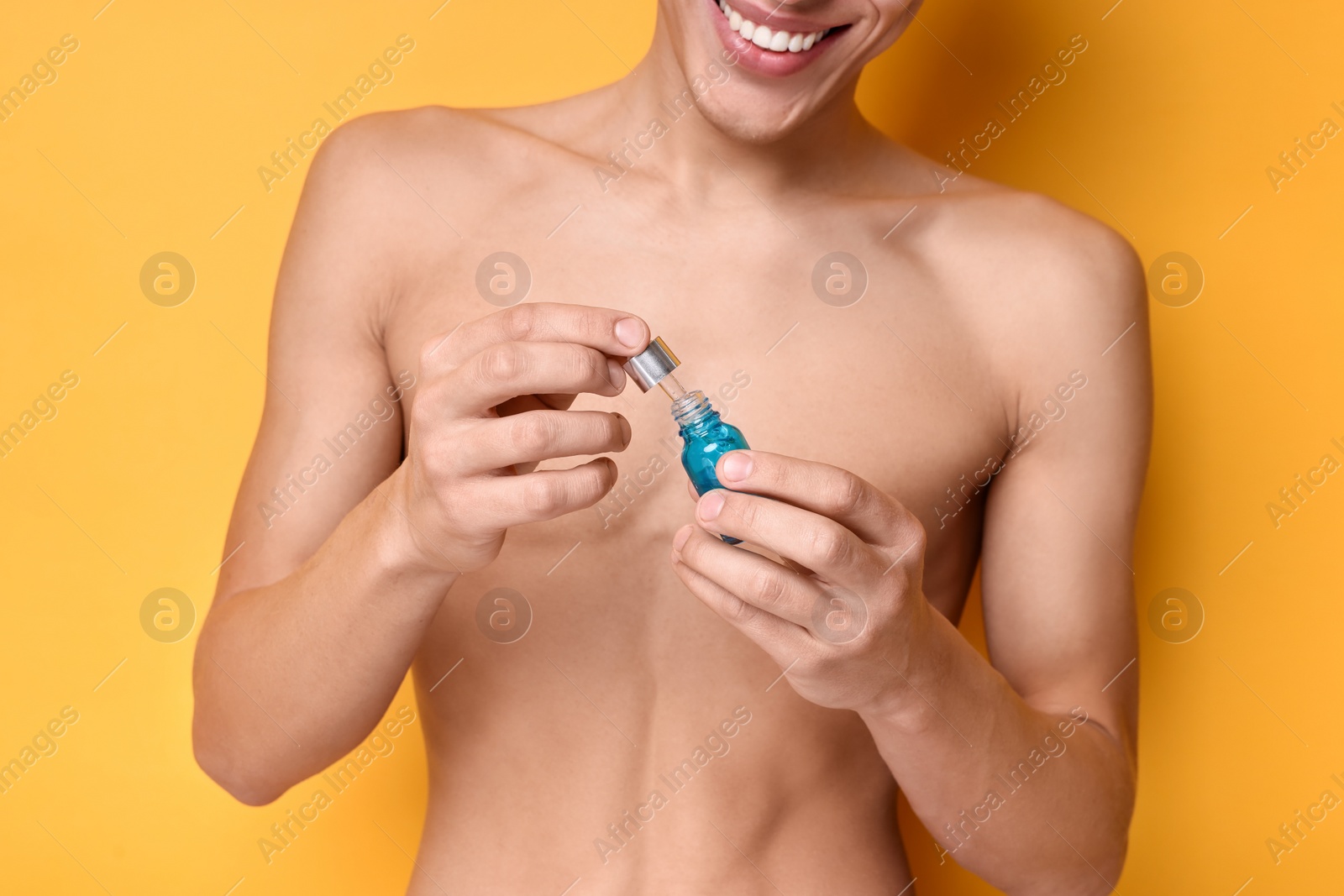 Photo of Man with serum on orange background, closeup