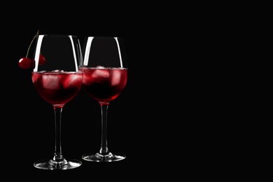 Photo of Delicious cherry wine with ripe juicy berries on black background. Space for text