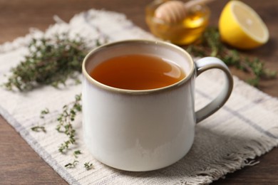 Photo of Aromatic herbal tea with thyme on wooden table