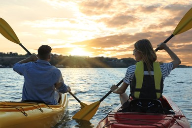 Photo of Couple kayaking on river, back view. Summer activity