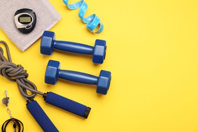 Photo of Flat lay composition with dumbbells on yellow background, space for text