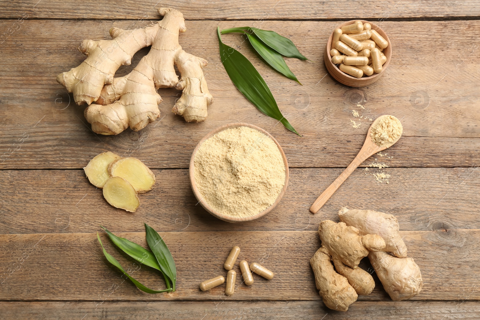 Photo of Flat lay composition with dry, fresh and capsuled ginger on wooden table