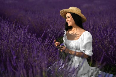 Photo of Beautiful young woman with bouquet sitting in lavender field