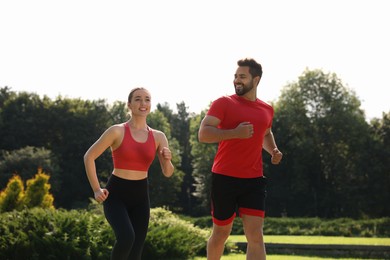 Photo of Healthy lifestyle. Happy couple running in park on sunny day