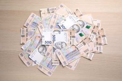 Photo of Ukrainian money on wooden background, flat lay