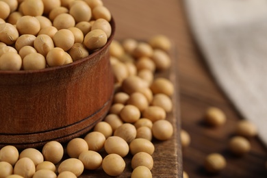 Photo of Natural soy beans on wooden table, closeup. Space for text