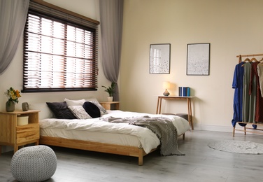 Photo of Modern room interior with comfortable double bed and window blinds