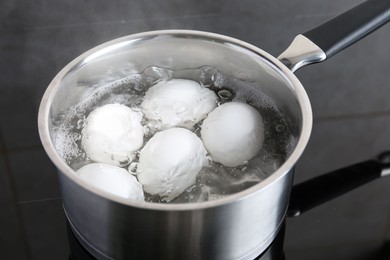 Chicken eggs boiling in saucepan on electric stove
