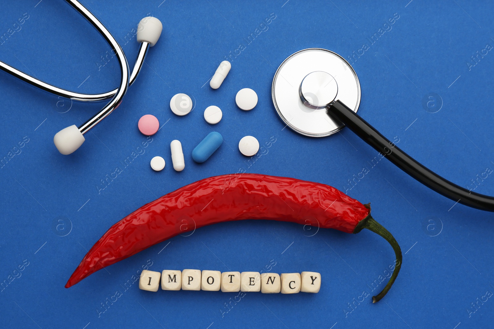 Photo of Flat lay composition of chili pepper and cubes with word Impotency on blue background