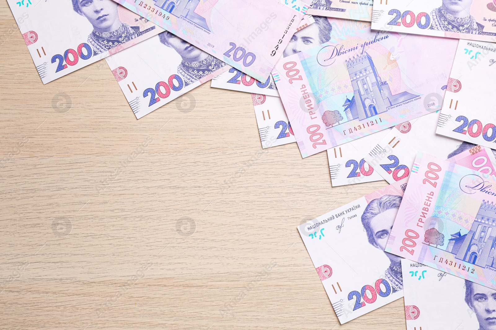 Photo of Ukrainian money on wooden background, flat lay. Space for text