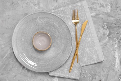 Photo of Elegant setting with shiny cutlery on grey table, top view