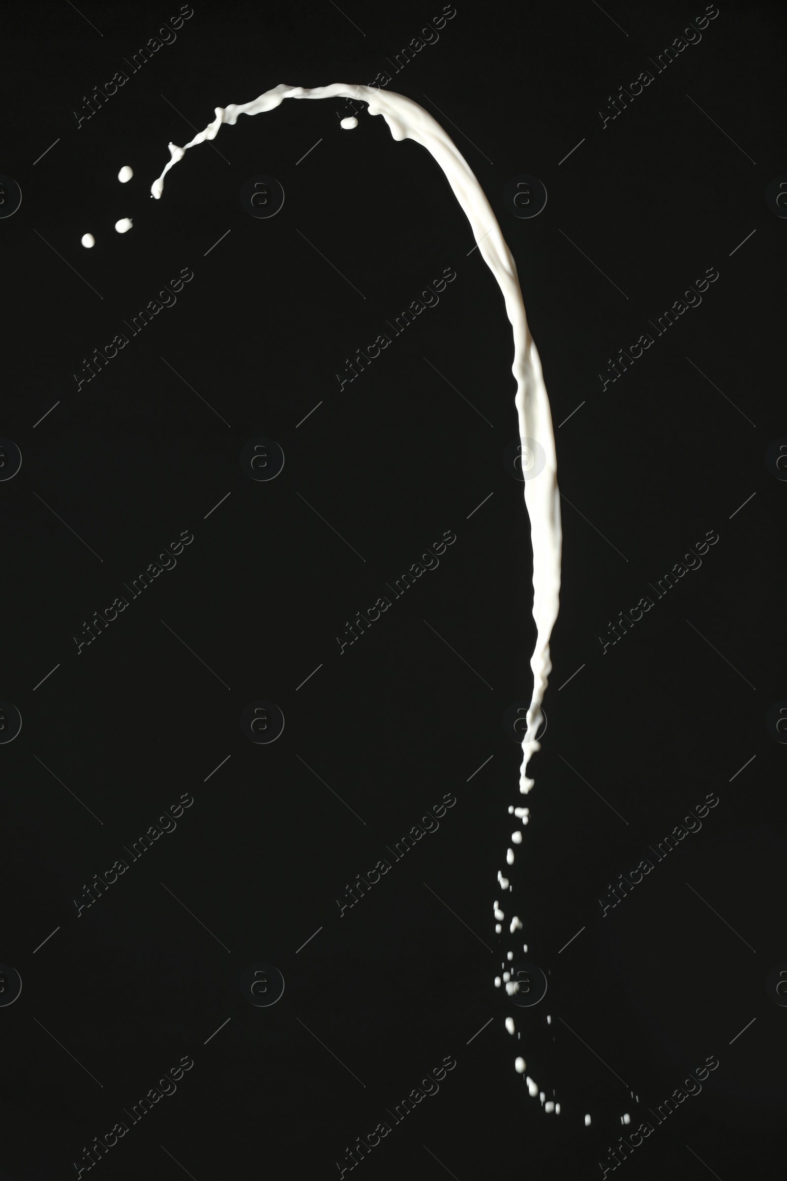 Photo of Splash of fresh milk on black background