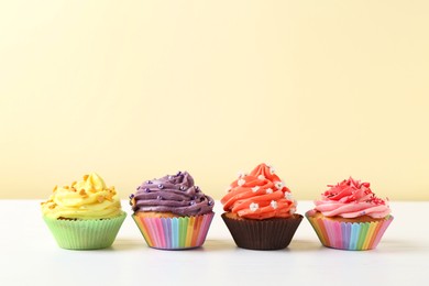 Delicious cupcake with bright cream on white wooden table. Space for text