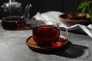 Tasty hot tea in cup on grey table, closeup