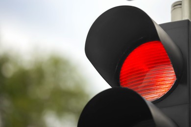 Photo of Closeup view of red traffic light in city. Space for text