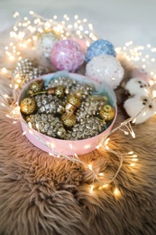 Photo of Beautiful Christmas tree baubles and fairy lights on faux fur