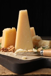 Delicious parmesan cheese with walnuts and rosemary on wooden table, closeup