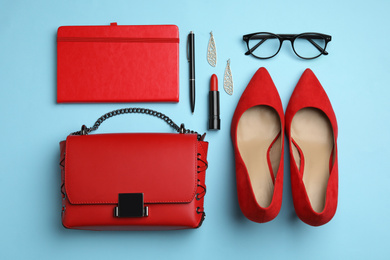Photo of Flat lay composition with stylish woman's bag and accessories on light blue background