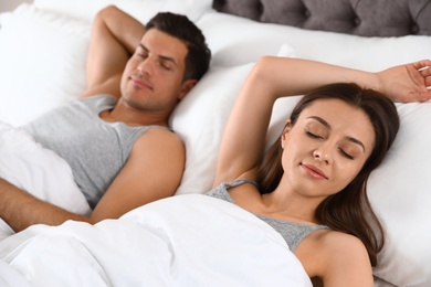 Portrait of lovely couple sleeping in large bed