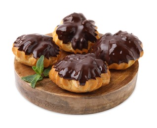 Photo of Delicious profiteroles with chocolate spread and mint isolated on white