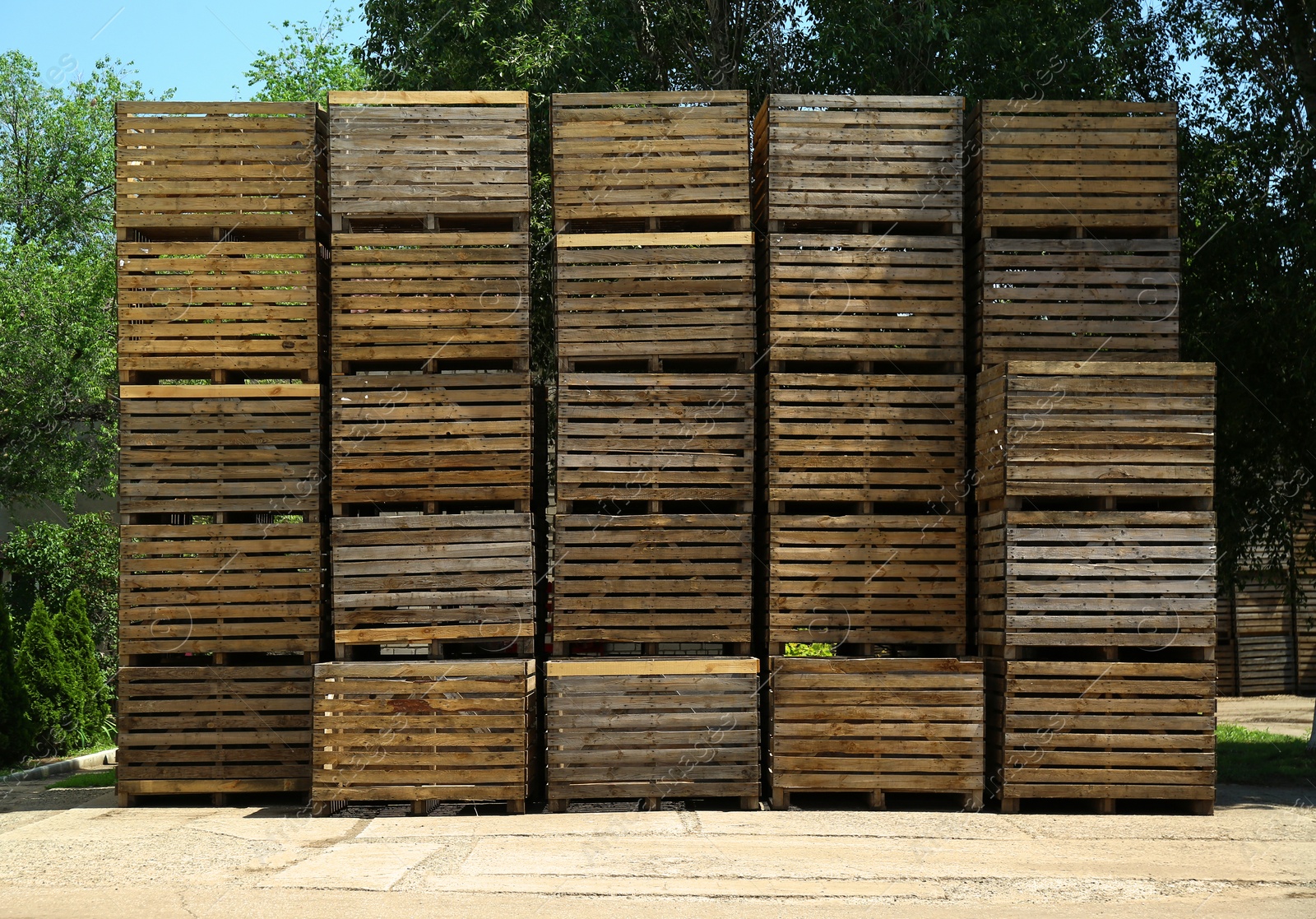 Photo of Pile of empty wooden crates at warehouse backyard on sunny day