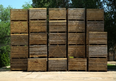 Pile of empty wooden crates at warehouse backyard on sunny day