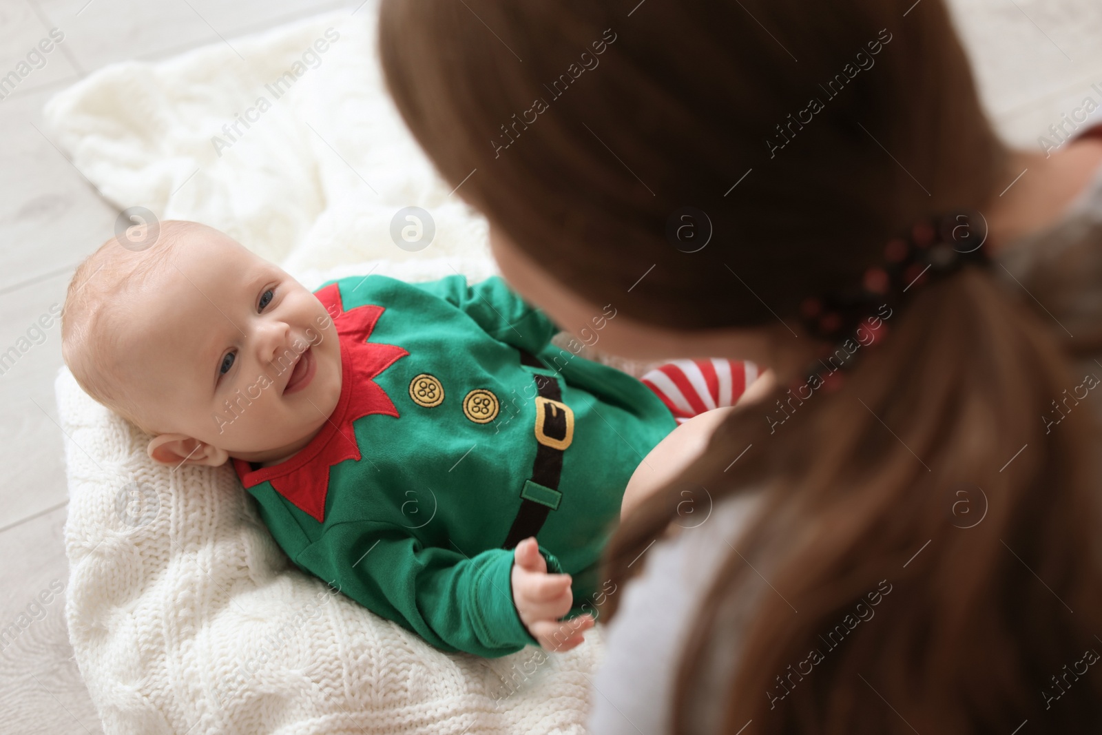 Photo of Cute baby in Christmas costume with mother at home