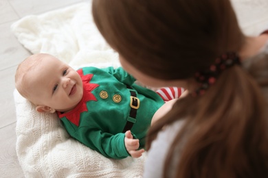 Cute baby in Christmas costume with mother at home