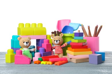 Photo of Different children's toys on grey wooden table against white background