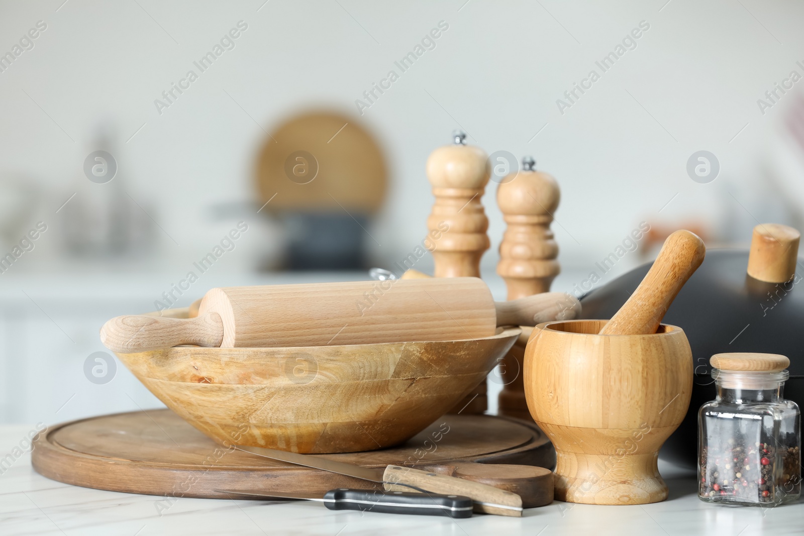 Photo of Set of cooking utensils on white table against blurred background