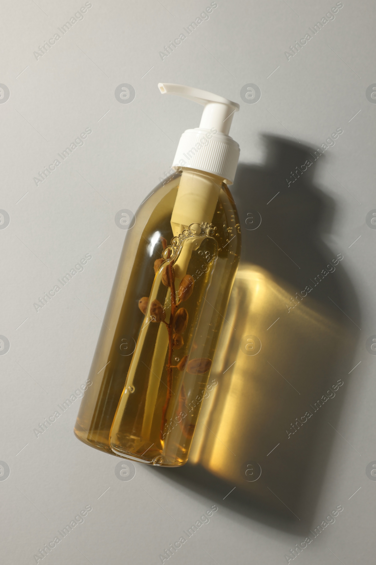 Photo of Bottle of liquid soap on light grey background, top view