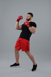 Photo of Man in boxing gloves on grey background