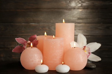 Photo of Beautiful composition with lit candles and flowers on table